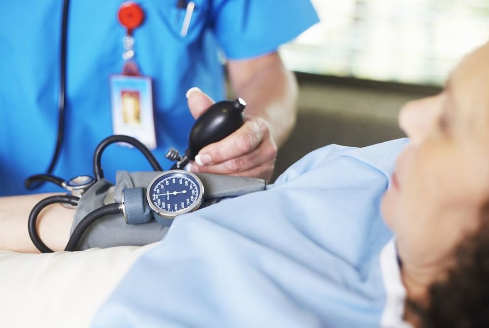 O médico mide a presión do paciente con hipertensión